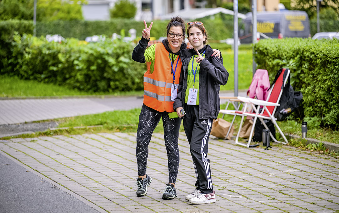 Ein Team von Streckenposten mit Funkgeräten sichert die Fahrradstrecke des Triathlon Stralsund und gibt Handzeichen zur Richtungsänderung.