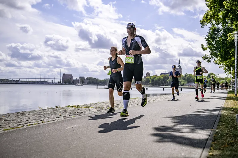Läuferinnen und Läufer auf der Uferpromenade in Stralsund auf dem Weg zium Ziel – des Triathlon Stralsund.